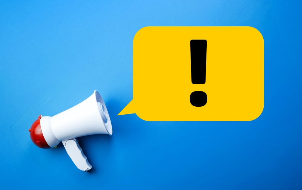 Megaphone with speech bubble containing large exclamation mark